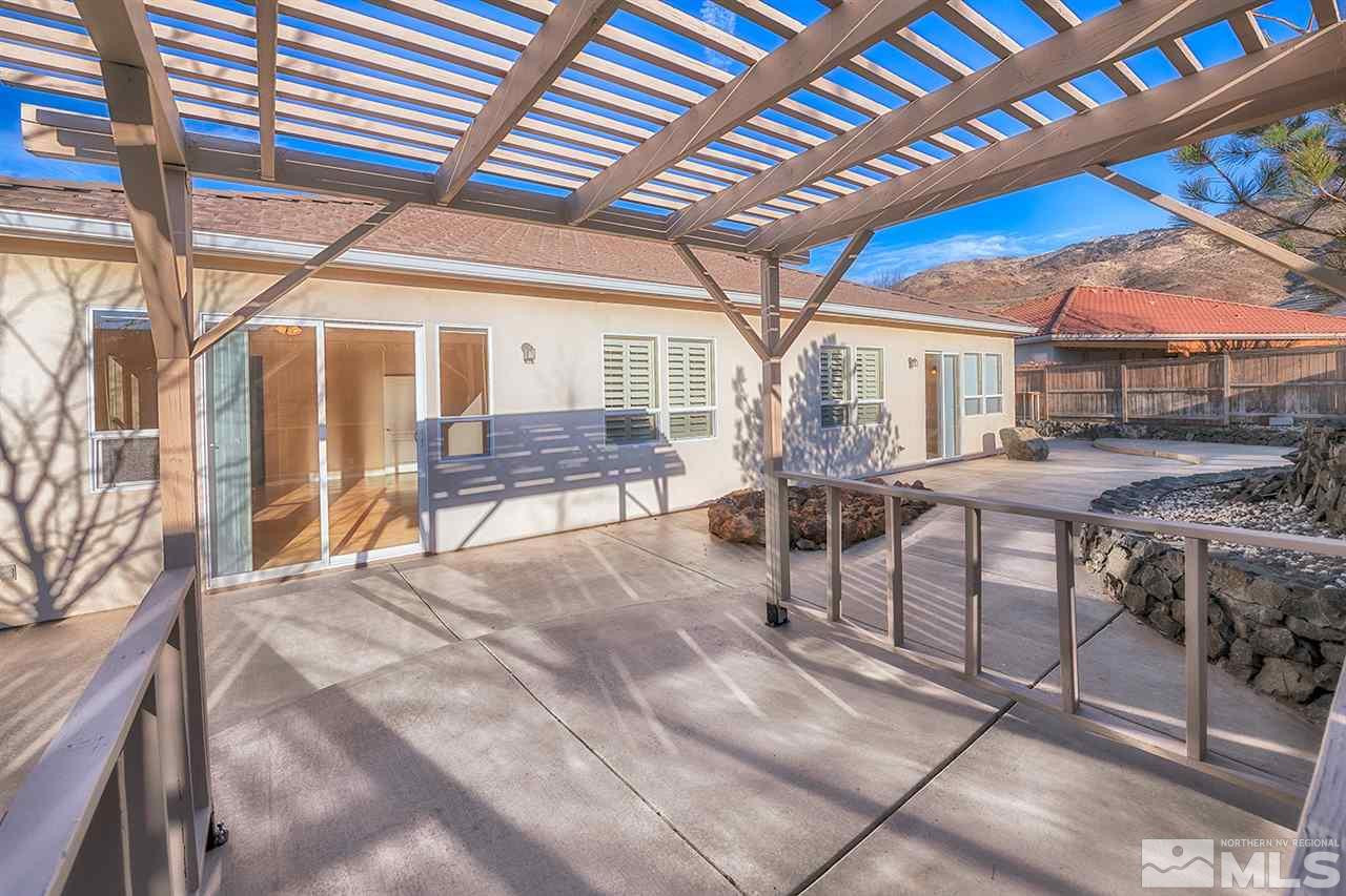 10645 Summer Glen Drive Reno, NV 89521 - Photo 24 of 25 a view of a patio with table and chairs and couches with wooden roof and stairs