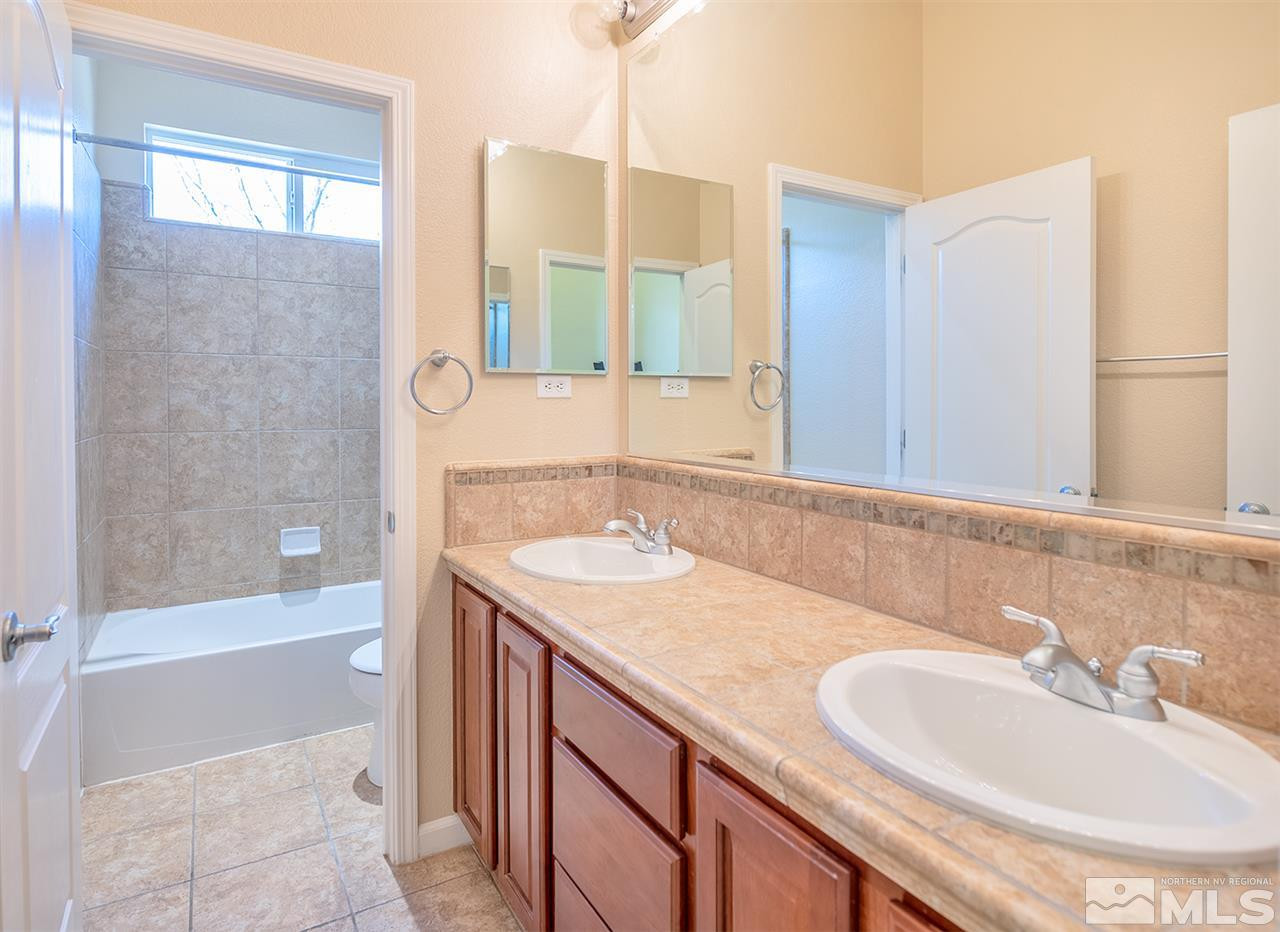 10645 Summer Glen Drive Reno, NV 89521 - Photo 9 of 25 a bathroom with a granite countertop sink and a mirror