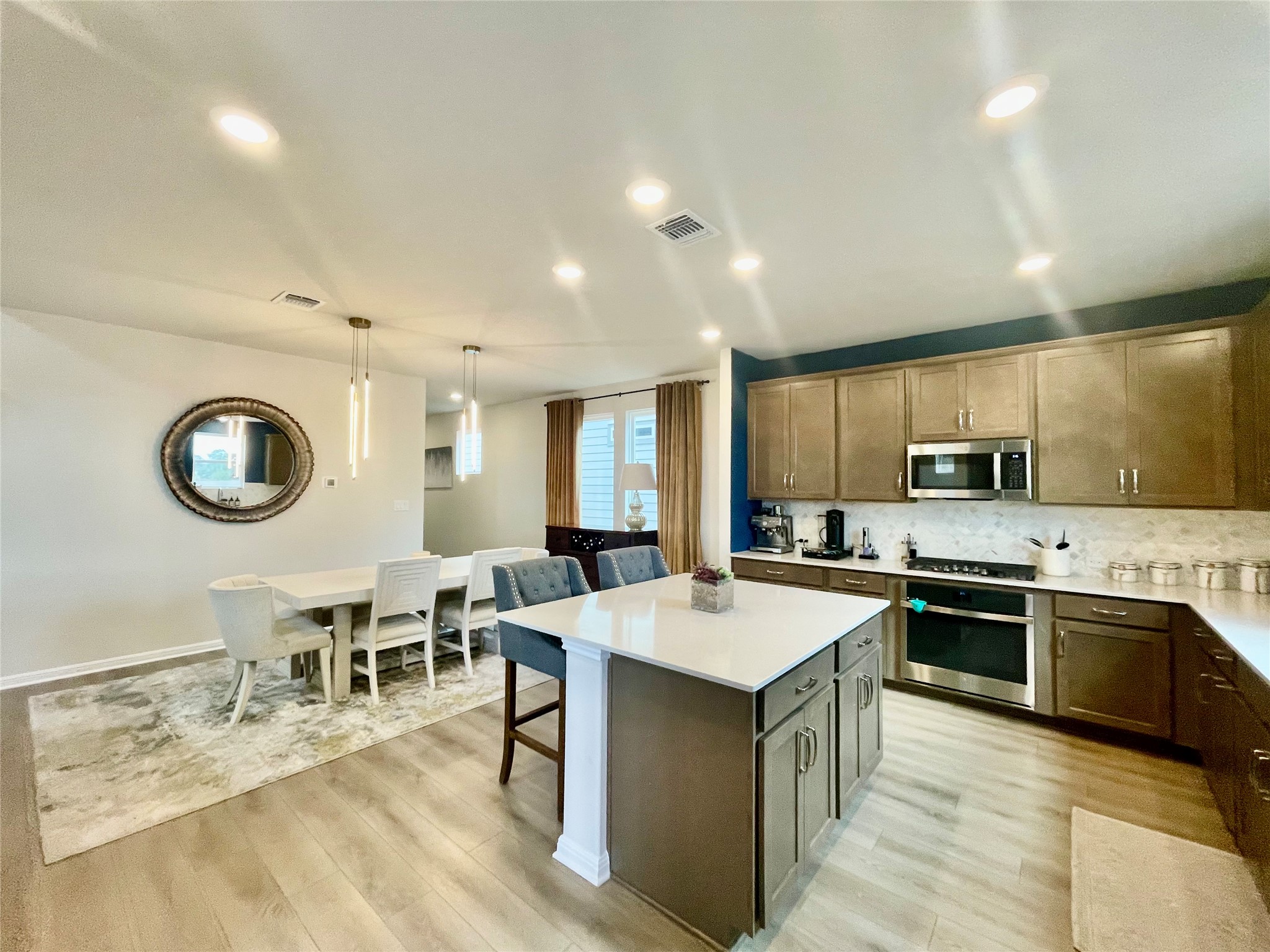 232 Denali Way Dripping Springs, TX 78620 - Photo 14 of 33 Kitchen featuring hanging light fixtures, a kitchen island, tasteful backsplash, stainless steel appliances, and a breakfast bar