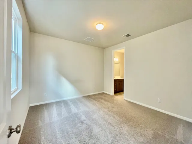 an empty room with an entryway and window