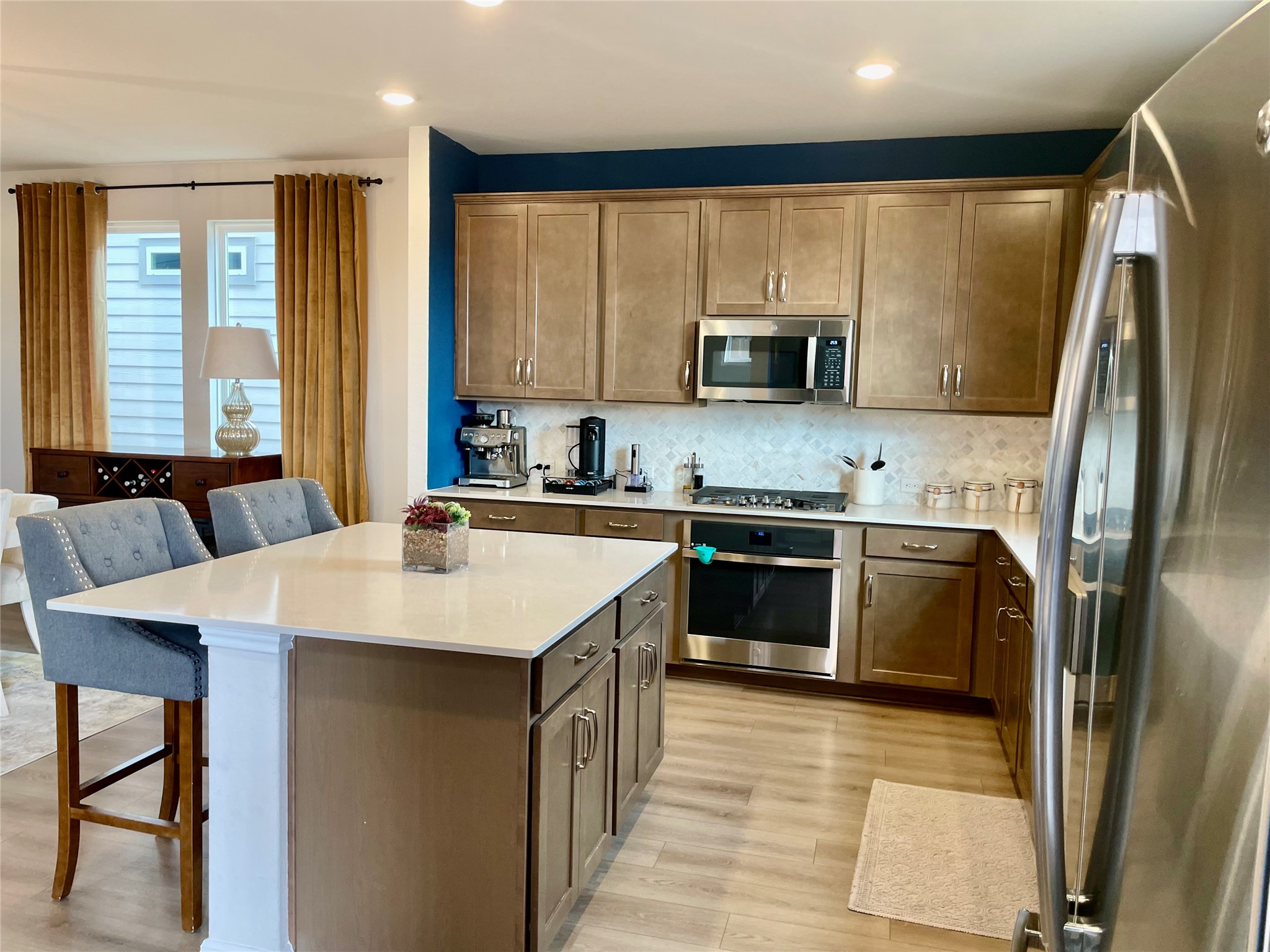 232 Denali Way Dripping Springs, TX 78620 - Photo 3 of 33 Kitchen with a breakfast bar area, stainless steel appliances, a center island, tasteful backsplash, and light stone countertops