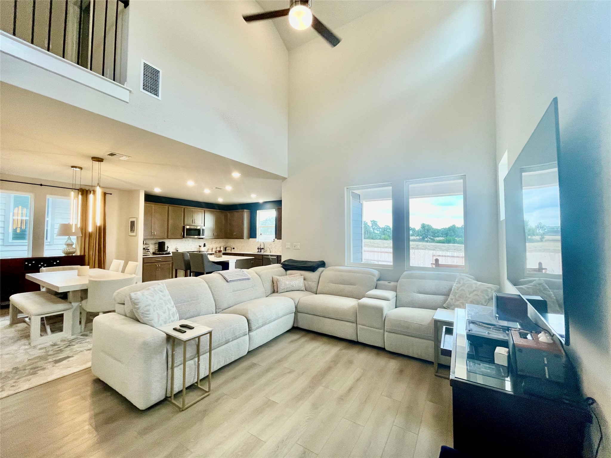 232 Denali Way Dripping Springs, TX 78620 - Photo 10 of 33 Living area featuring light wood finished floors, ceiling fan, and a high ceiling