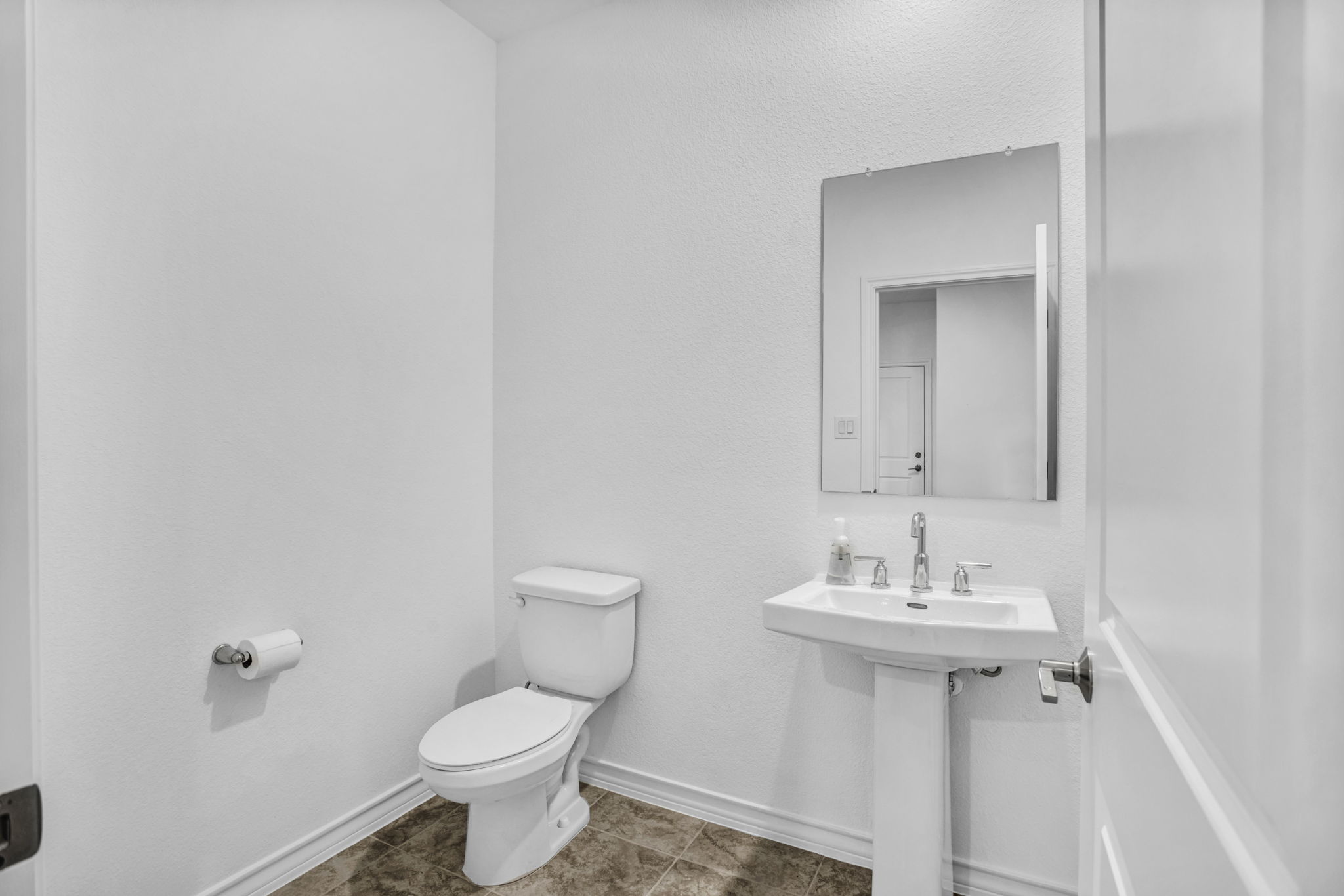 131 Adeline Road Hutto, TX 78634 - Photo 11 of 30 A well-lit powder room offers practical elegance with a pedestal sink and tile flooring.