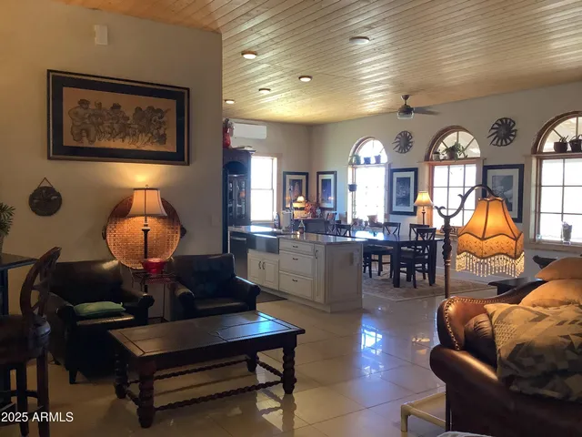 a living room with furniture a chandelier and a large window
