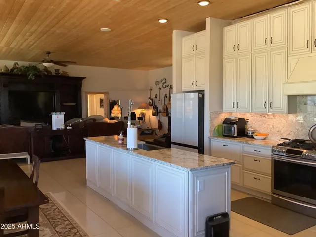 a kitchen with stainless steel appliances kitchen island granite countertop a stove a sink and a refrigerator