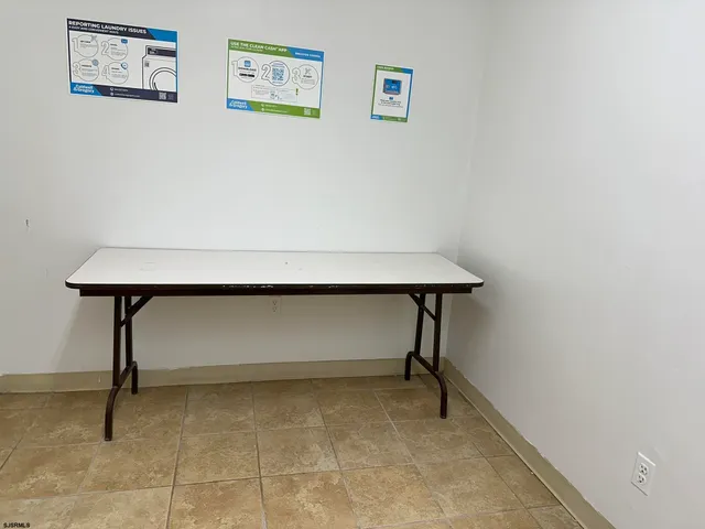 a room with a table and paintings on the wall