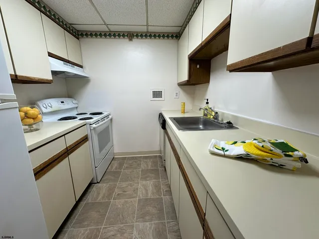 a kitchen with a sink a stove and cabinets