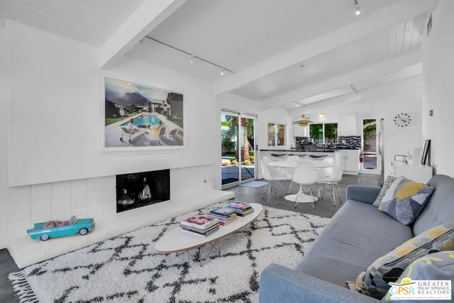 a living room with furniture a rug and a potted plant