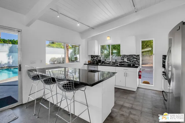 a kitchen with a refrigerator a counter space and stainless steel appliances