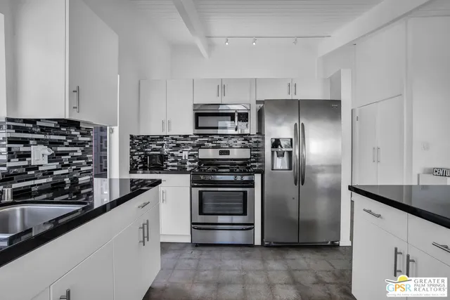 a view of a kitchen counter space a sink and refrigerator