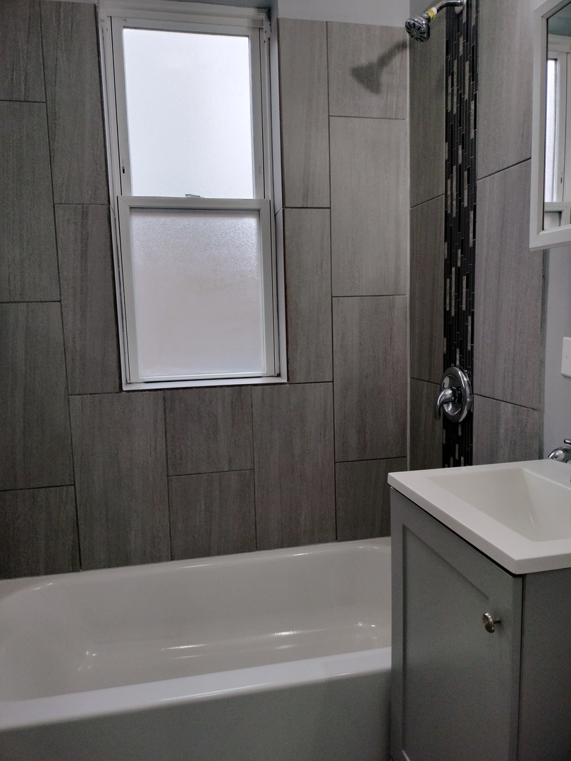 6601 South Green Street, Unit 8171 Chicago, IL 60621 - Photo 16 of 28 a bathroom with a bathtub and a shower