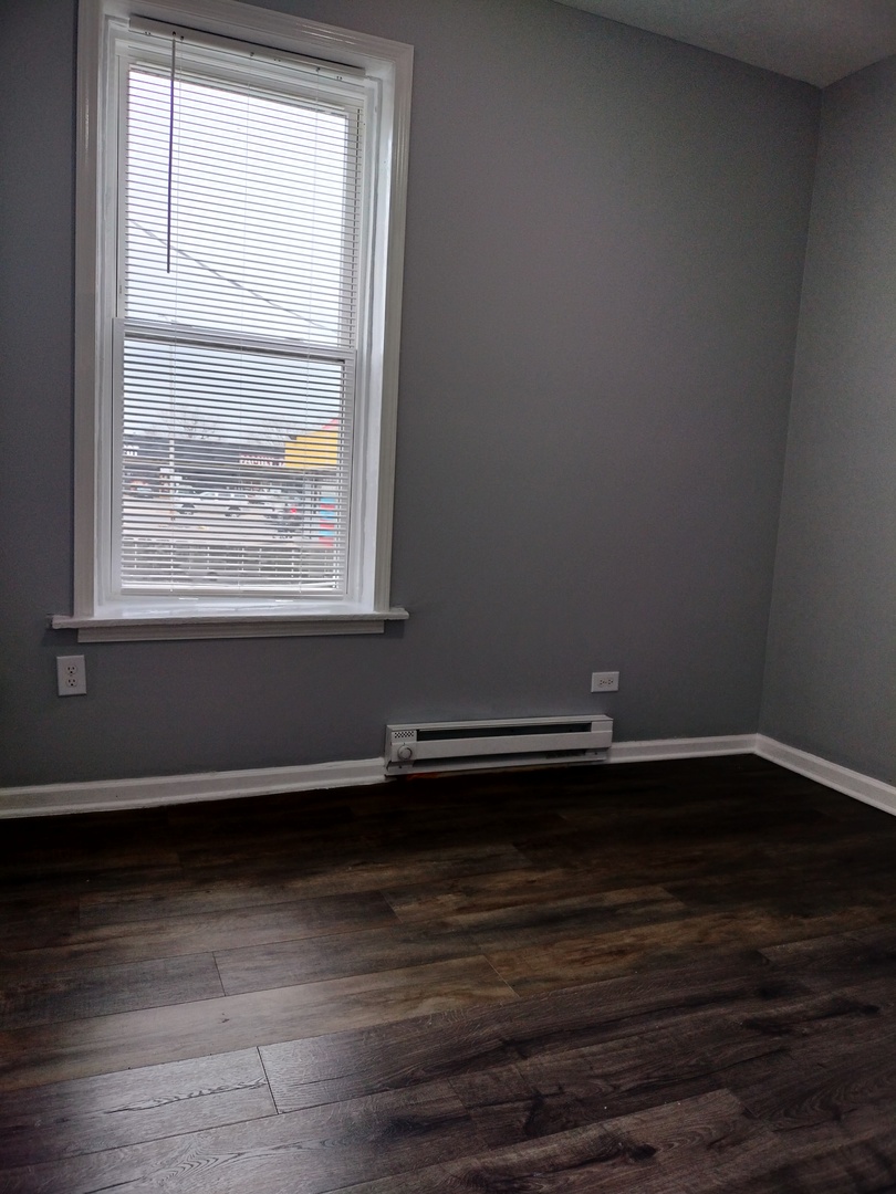 6601 South Green Street, Unit 8171 Chicago, IL 60621 - Photo 18 of 28 an empty room with wooden floor and a window