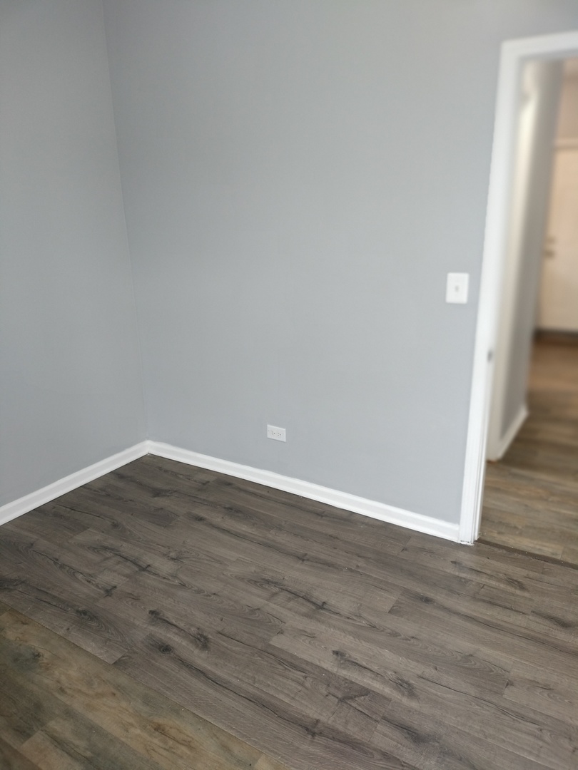 6601 South Green Street, Unit 8171 Chicago, IL 60621 - Photo 20 of 28 a view of an empty room with wooden floor and a window