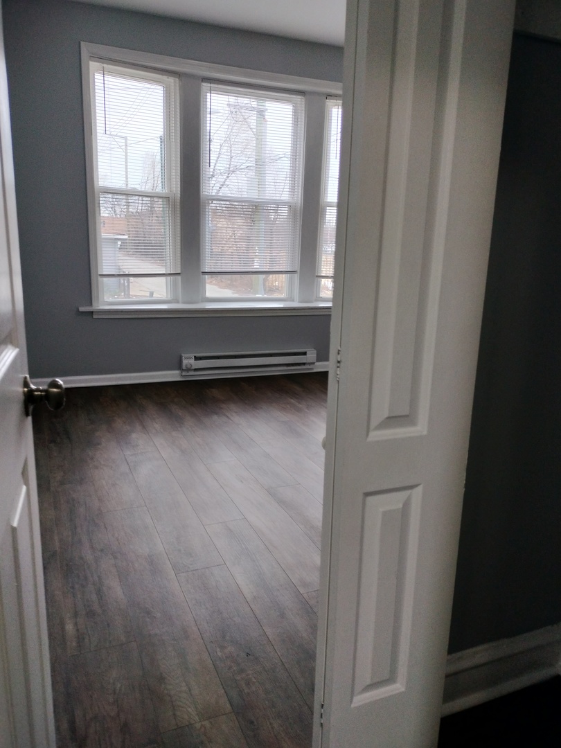 6601 South Green Street, Unit 8171 Chicago, IL 60621 - Photo 25 of 28 a view of an empty room with wooden floor and a window
