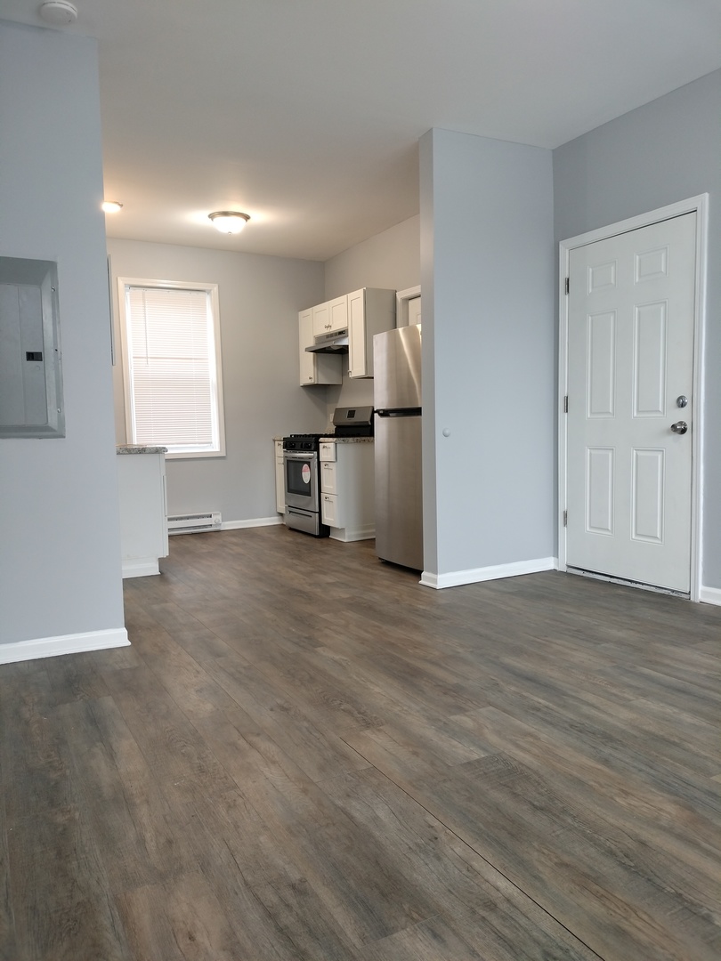 6601 South Green Street, Unit 8171 Chicago, IL 60621 - Photo 5 of 28 a view of kitchen and empty room with wooden floor
