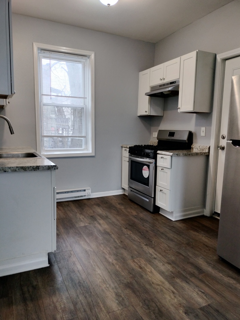 6601 South Green Street, Unit 8171 Chicago, IL 60621 - Photo 6 of 28 a kitchen with stainless steel appliances granite countertop a stove a sink and a microwave