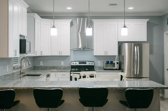 a kitchen with stainless steel appliances granite countertop a sink a stove and a refrigerator