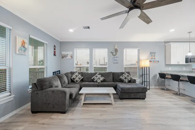 a living room with furniture and a view of kitchen