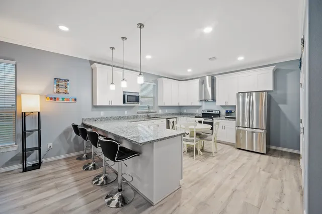 a kitchen with a table chairs refrigerator and microwave