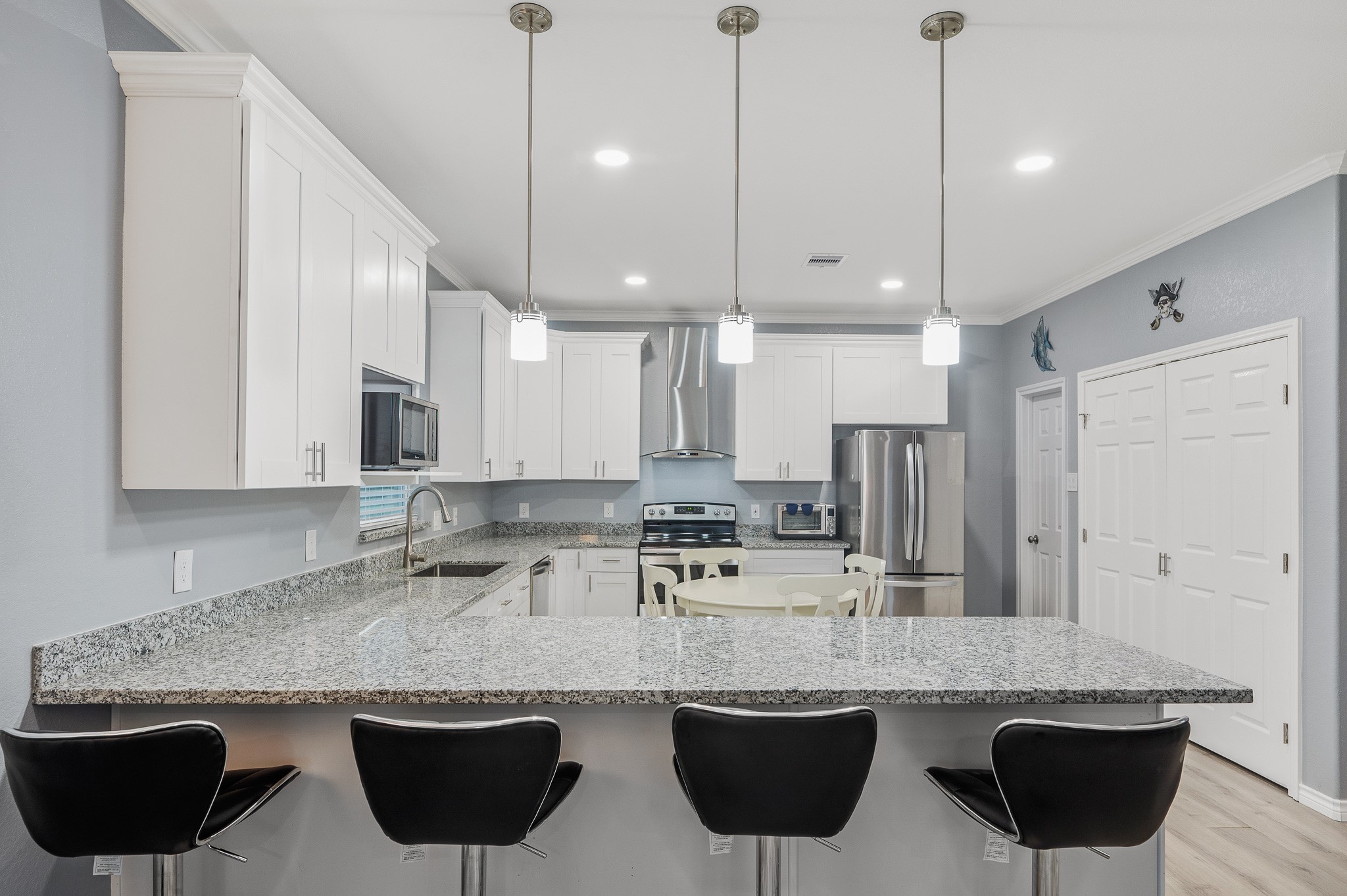 305 Jettyview Road, Unit A Surfside Beach, TX 77541 - Photo 8 of 41 a kitchen with stainless steel appliances granite countertop a sink a stove a refrigerator and island with wooden floor