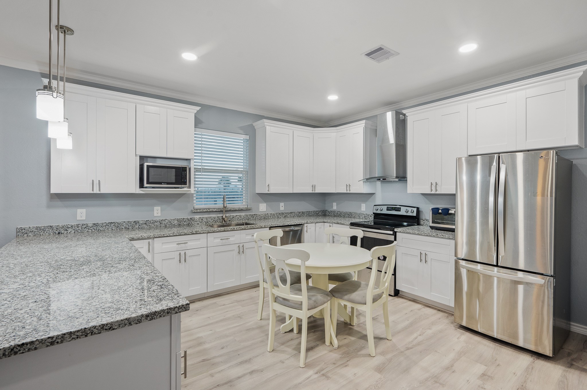 305 Jettyview Road, Unit A Surfside Beach, TX 77541 - Photo 9 of 41 a kitchen with granite countertop stainless steel appliances a refrigerator a stove top oven a sink and white cabinets