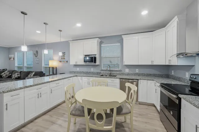 a kitchen with white cabinets stove and sink