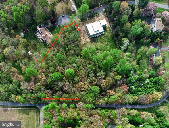 an aerial view of residential house with outdoor space and trees all around