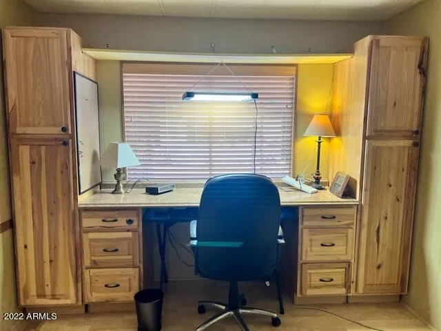 a view of a workspace with furniture and a window