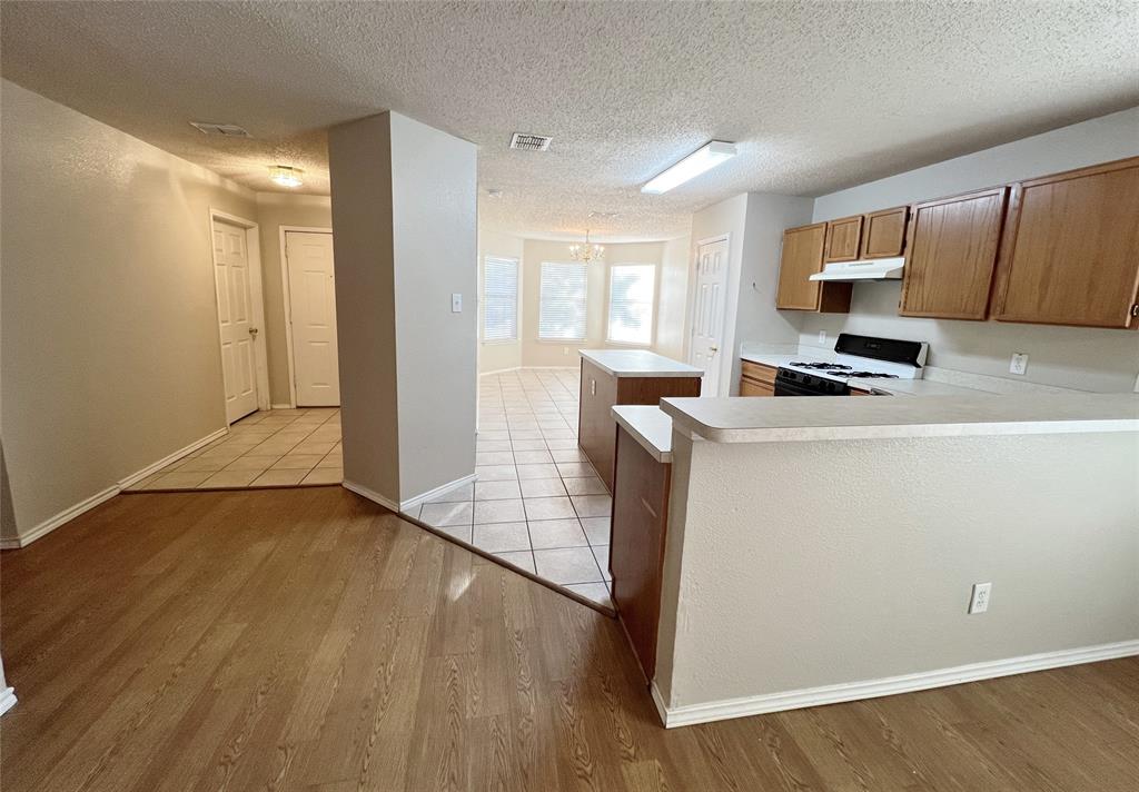 2217 Lookout Lane Denton, TX 76207 - Photo 2 of 18 a kitchen with stainless steel appliances a stove a sink a microwave a refrigerator a cabinets and wooden floor