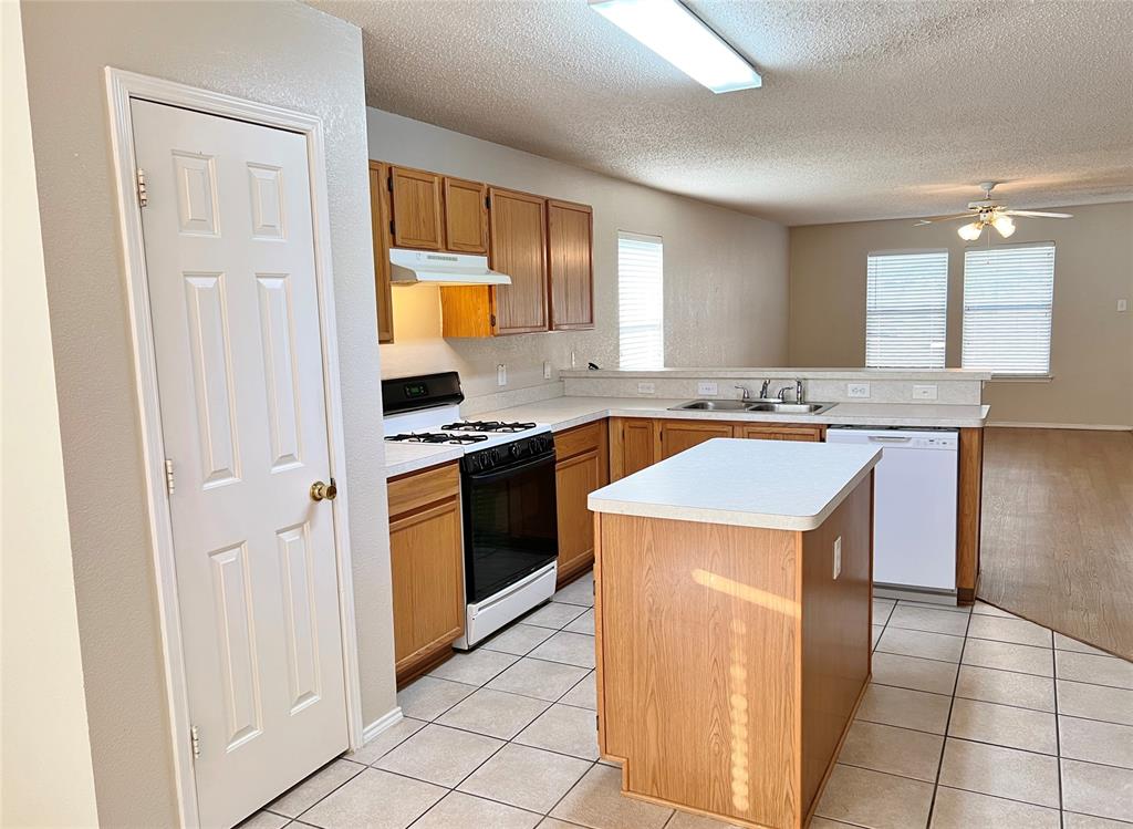 2217 Lookout Lane Denton, TX 76207 - Photo 5 of 18 a kitchen with a stove a sink and a refrigerator