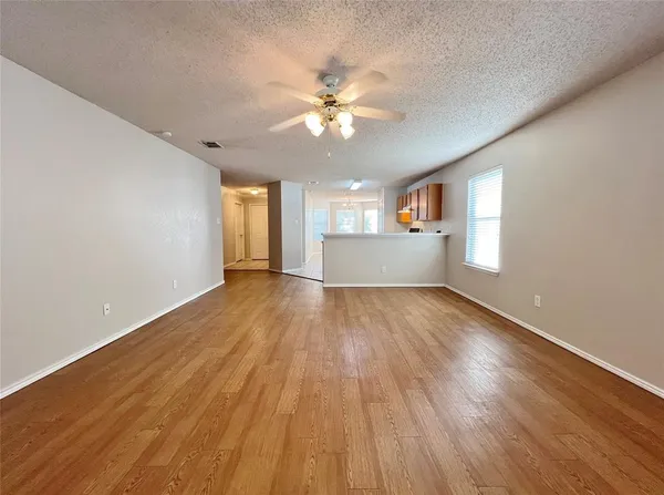 a view of a big room with wooden floor and windows