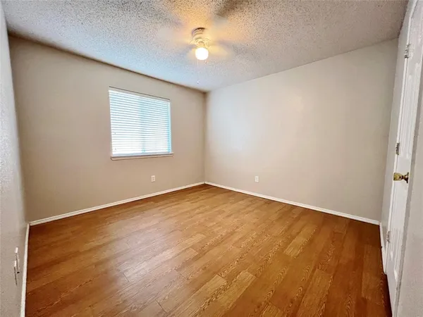 an empty room with a window and a ceiling fan