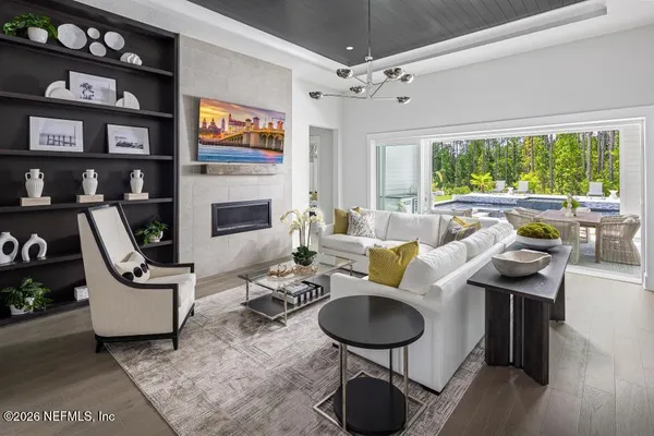 a living room with furniture a fireplace and a large window
