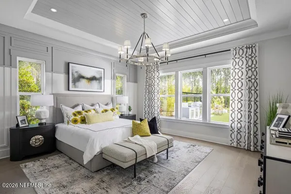 a spacious bedroom with a bed and a chandelier