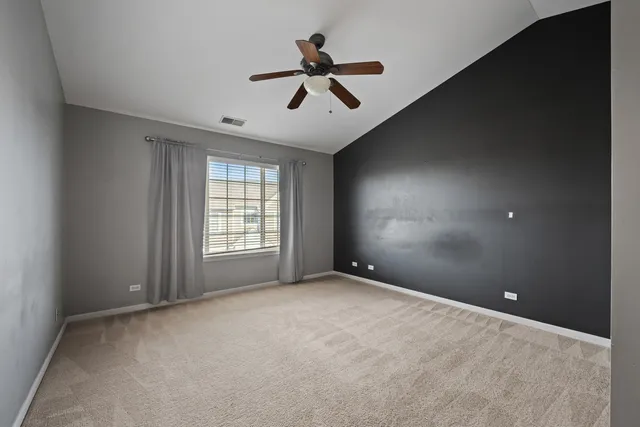 an empty room with fan and windows