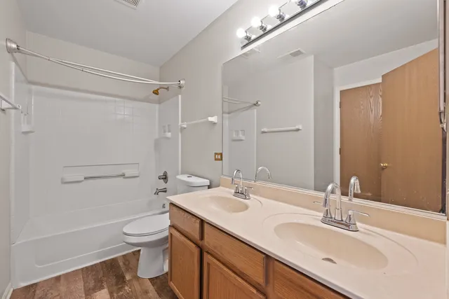 a bathroom with a sink a toilet a mirror and shower