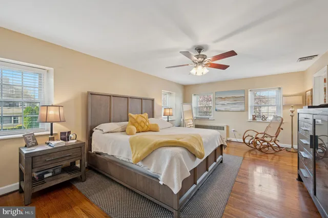 a bedroom with bed a table and a large window