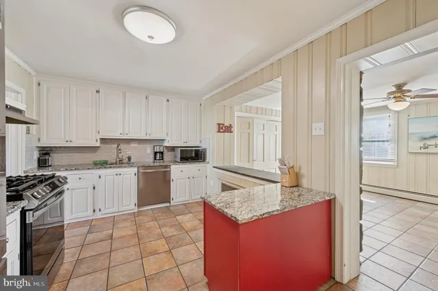 a kitchen with granite countertop a sink stove and refrigerator