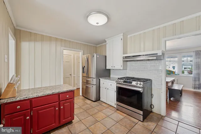 a kitchen with stainless steel appliances granite countertop a stove a sink and a refrigerator