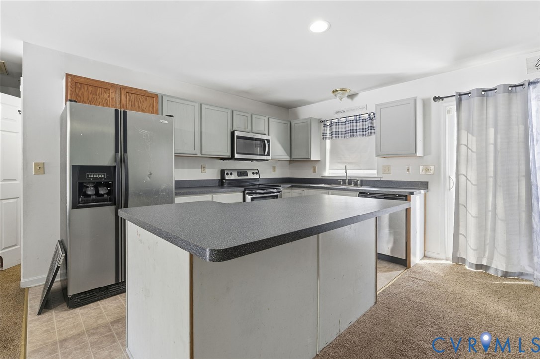 204 Village Court Ruther Glen, VA 22546 - Photo 7 of 27 a kitchen with kitchen island a sink stove and refrigerator