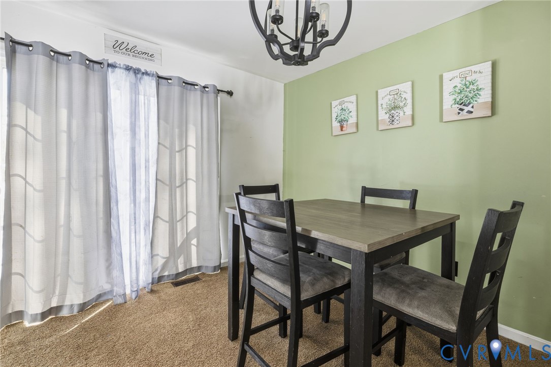 204 Village Court Ruther Glen, VA 22546 - Photo 8 of 27 a view of a dining room with furniture and a chandelier