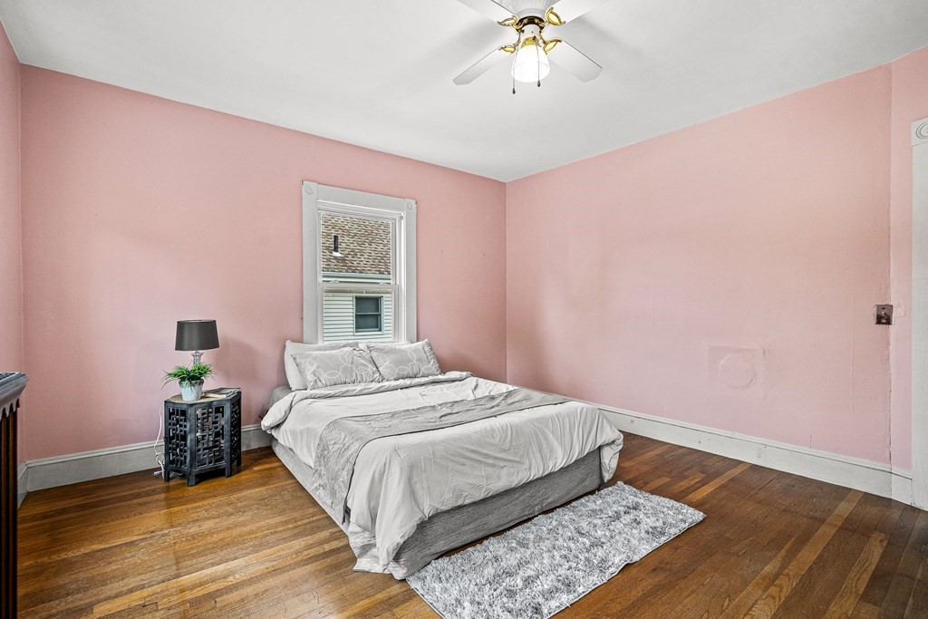 14 Hancock Street Stoneham, MA 02180 - Photo 17 of 38 a bedroom with a large bed and a chandelier