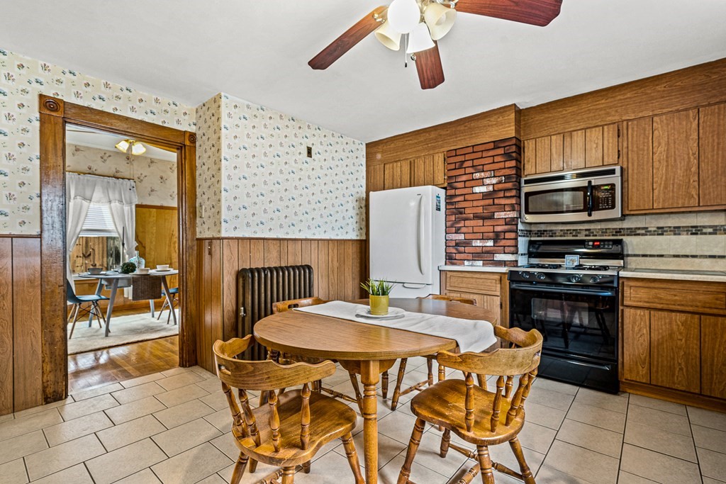 14 Hancock Street Stoneham, MA 02180 - Photo 8 of 38 a kitchen with a table chairs and a refrigerator