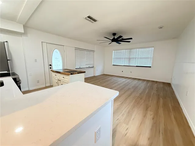 a view of a kitchen with a sink dishwasher microwave and a dining table with wooden floor
