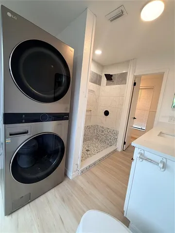 an empty room with wooden floor closet and windows