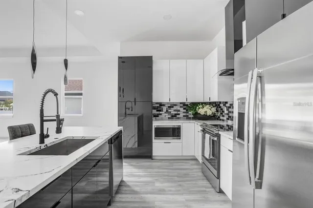 a kitchen with stainless steel appliances granite countertop a sink stove and refrigerator