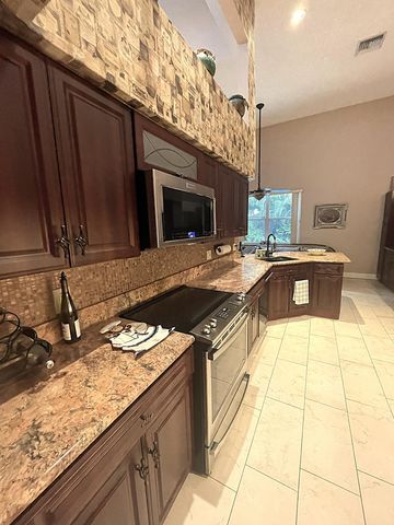a kitchen with stainless steel appliances granite countertop a sink stove and cabinets