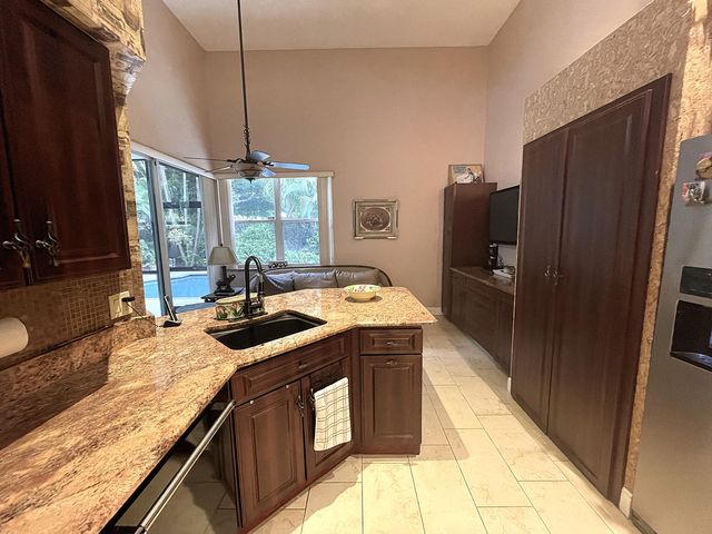 a kitchen with granite countertop a sink stove and refrigerator