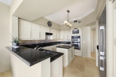 a kitchen with stainless steel appliances granite countertop a sink a stove and a refrigerator