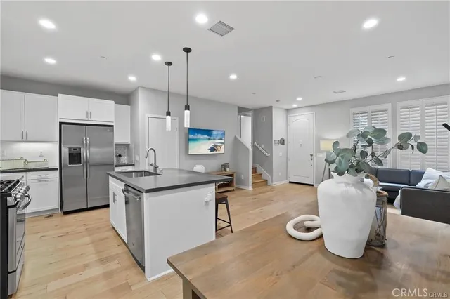 a kitchen with refrigerator and chairs